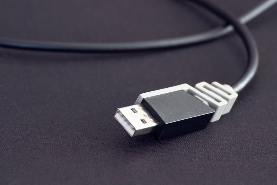 A close-up of a black USB cable connector on a dark background.