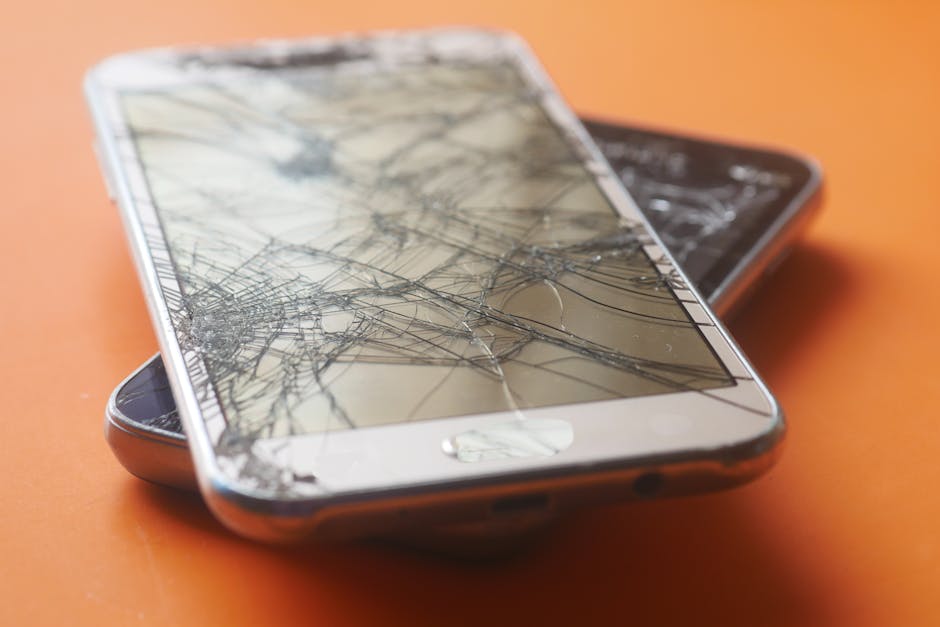 Two damaged smartphone screens on an orange background.